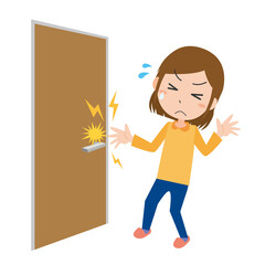 ドアノブを握ろうとして静電気に痛がる女性