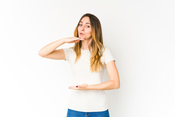 Young caucasian woman isolated on white background holding something with both hands, product presentation.