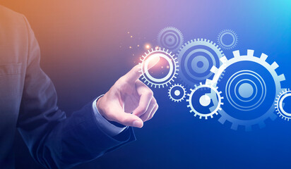 Businessman Pushing Button Turning On Cogwheels Mechanism Over Blue Background