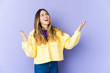 Young caucasian woman isolated on purple background screaming to the sky, looking up, frustrated.