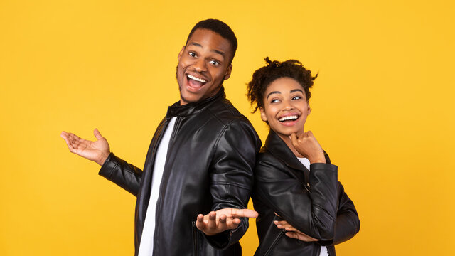 Cheerful African Boyfriend And Girlfriend Standing Back-To-Back Over Yellow Background