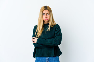 Young blonde woman isolated on white background blows cheeks, has tired expression. Facial expression concept.