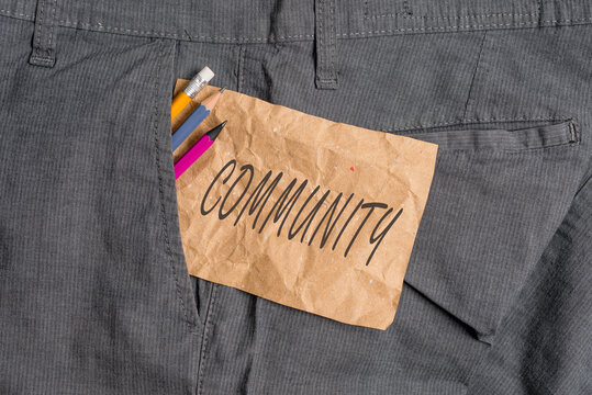 Word writing text Community. Business photo showcasing group of showing with a common characteristics living together Writing equipment and brown note paper inside pocket of man work trousers