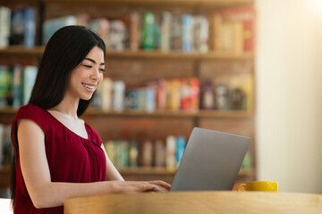 Smiling Asian Female Student Preparing For Classes With Laptop In Cafe