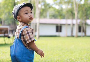 Asian toddler boy playing in garden