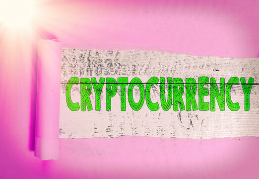 Text sign showing Cryptocurrency. Business photo showcasing form of currency that exists digitally has no central issuing Rolled ripped torn cardboard placed above a wooden classic table backdrop