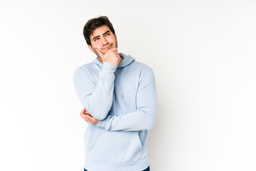 Young man isolated on white background thinking and looking up, being reflective, contemplating, having a fantasy.