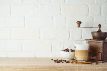 Kitchen background with coffee cup and coffee mill grinder on wooden shelf