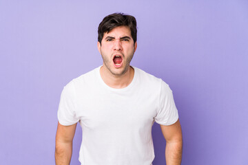 Obraz premium Young man isolated on purple background shouting very angry, rage concept, frustrated.