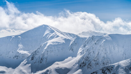 View from Kasprowy Wierch at mountain peak at winter. Amazing mountain range with snow capped mountain peaks in Tatra Mountains, Poland