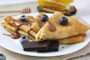 crepes with blueberries. pancakes with fruit. pancakes with berries. pancakes with honey, raspberries, blueberries and chocolate