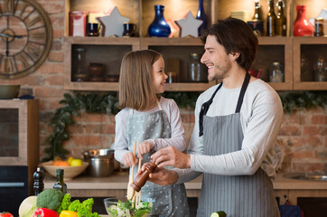 Joyful Young Dad And Little Daughter Cooking Vegetable Salad For Lunch Together