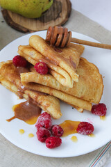 pancakes with fruit. pancakes with berries. pancakes with honey, raspberries and pears