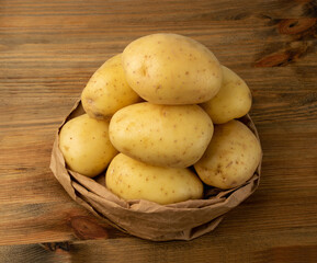 Raw Potatoes on Wooden Cutting Board Background