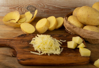Raw Grated Potato on Wooden Cutting Board Background