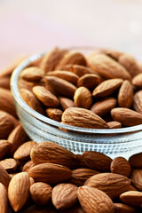 Almonds in bowl, Group of almond nuts isolated on white background. Depth of field