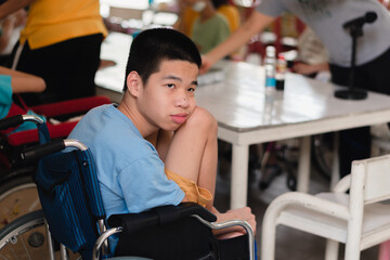 Asian special child on wheelchair is boredom with classroom activities with moody face while learning in school, Life in the education age of disabled children.