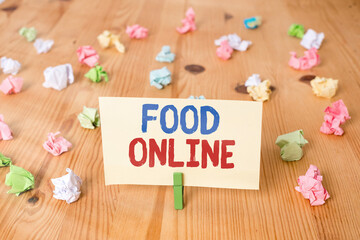Conceptual hand writing showing Food Online. Concept meaning the practice of taking action to improve one s is own health Colored crumpled papers wooden floor background clothespin