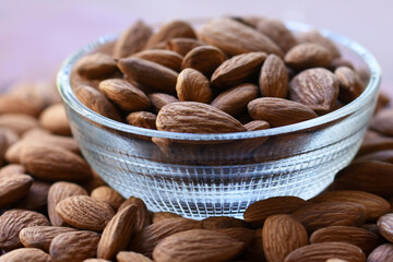 Almonds in bowl, Group of almond nuts isolated on white background. Depth of field