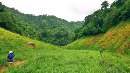 Young woman backpacker taking photos at mountain view.