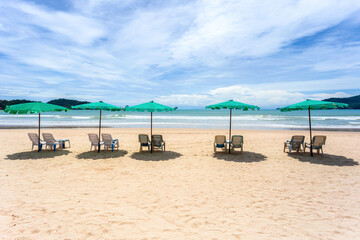 Beach umbrella made of palm leafs on a perfect white beach in front of sea in at Patong Beach, Phuket, Thailand