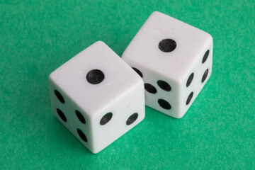 snake eyes - a pair of dice on a green background showing one and one