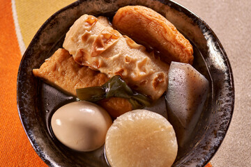 黒い皿に盛りつけられたおでん（煮物）