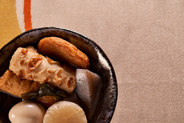 黒い皿に盛りつけられたおでん（煮物）