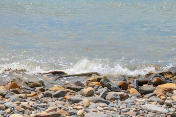 pebbles and stones on the beach. waves and splashes on the shore