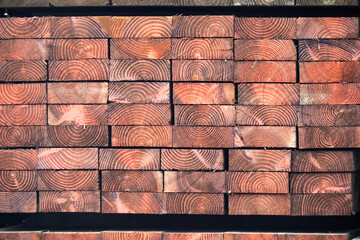 end grain of stacks of heavy industrial pressure treated wood planks
