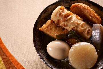 黒い皿に盛りつけられたおでん（煮物）