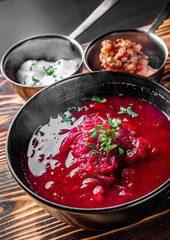 Beetroot soup Traditional Ukrainian or Russian borscht with sour cream in a bowl on wooden table