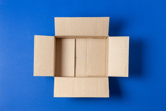 One Empty Open Brown Cardboard Box On Blue Background. Top View