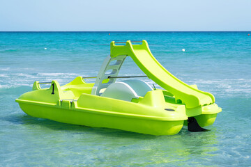 Green pedal boat on Sardinian sea in a turquoise sea.