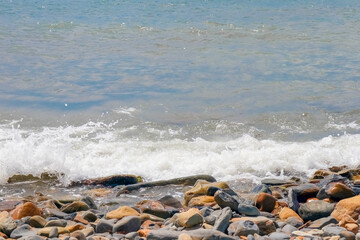 pebbles and stones on the beach. waves and splashes on the shore