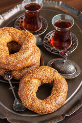 Turkish bagel simit and tea  in glass cup on wooden table