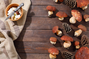 Harvest concept. Wild porcini mushrooms in a handmade wicker basket on a wooden background top view. Flat lay.