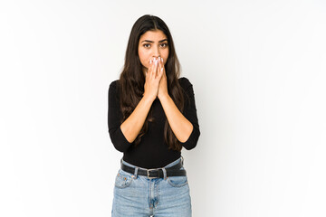 Young indian woman isolated on purple background covering mouth with hands looking worried.