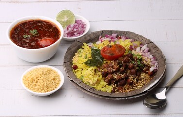 Aloo/Kanda Poha or Tarri Pohe with spicy chana masala/curry. Served in paper plate.