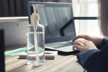 Antibacterial hand sanitizer gel for killing disease with woman working from home in quarantine for...