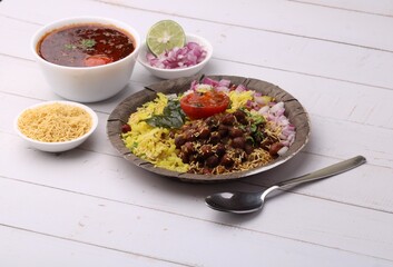 Aloo/Kanda Poha or Tarri Pohe with spicy chana masala/curry. Served in paper plate.