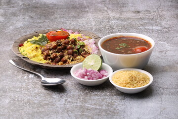 Aloo/Kanda Poha or Tarri Pohe with spicy chana masala/curry. Served in paper plate.