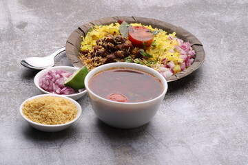 Aloo/Kanda Poha or Tarri Pohe with spicy chana masala/curry. Served in paper plate.