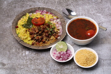 Aloo/Kanda Poha or Tarri Pohe with spicy chana masala/curry. Served in paper plate.