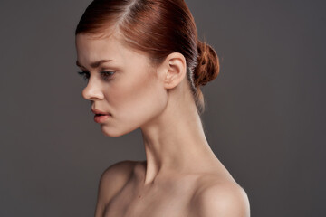 Beautiful woman naked shoulders cosmetics clean skin charm gray background studio
