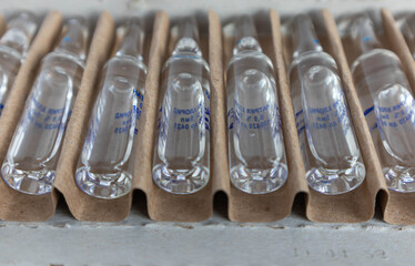 Transparent glass medical ampoules in cardboard packaging. Ampoules with medicine for injection.