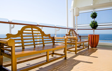 Zwei Holzbänke auf Deck von Cunard Kreuzfahrtschiff - Deck chairs and sun loungers on pool or sun...