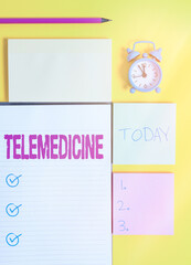 Text sign showing Telemedicine. Business photo showcasing practice medicine when the examining and patient are separated Colored empty papers with copy space on the yellow background table