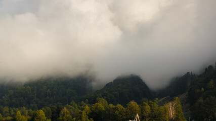 Obraz premium Misty mountain landscape with fir forest. Beautiful landscape with mountain view, cable car. Postcard view. Travel concept. Sunset, Golden hour