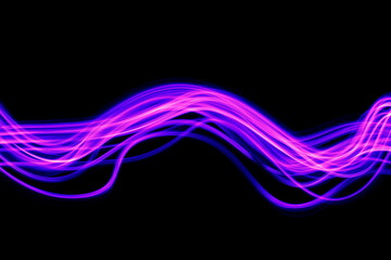 Obraz premium Long exposure photograph of purple neon colour in an abstract swirl, parallel lines pattern against a black background. Light painting photography.